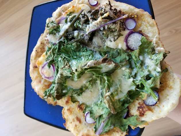 Naan pizza with kale, mozzarella, and thin radish slices